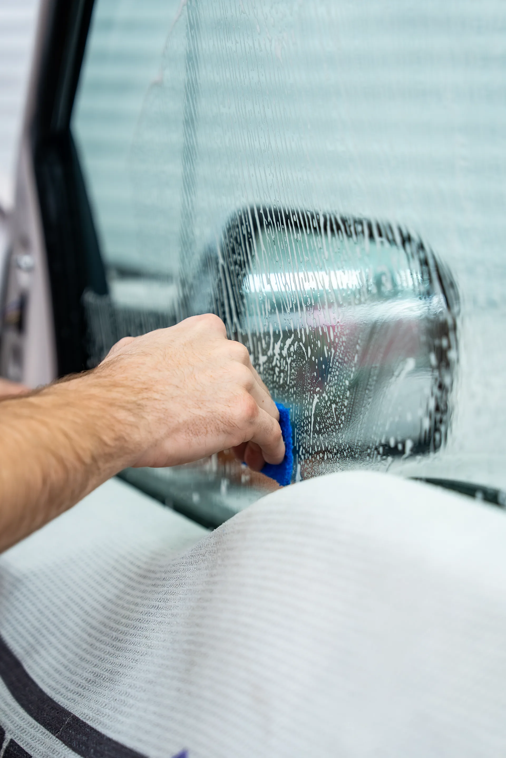 Soapy window being prepped with a squeegee before film application