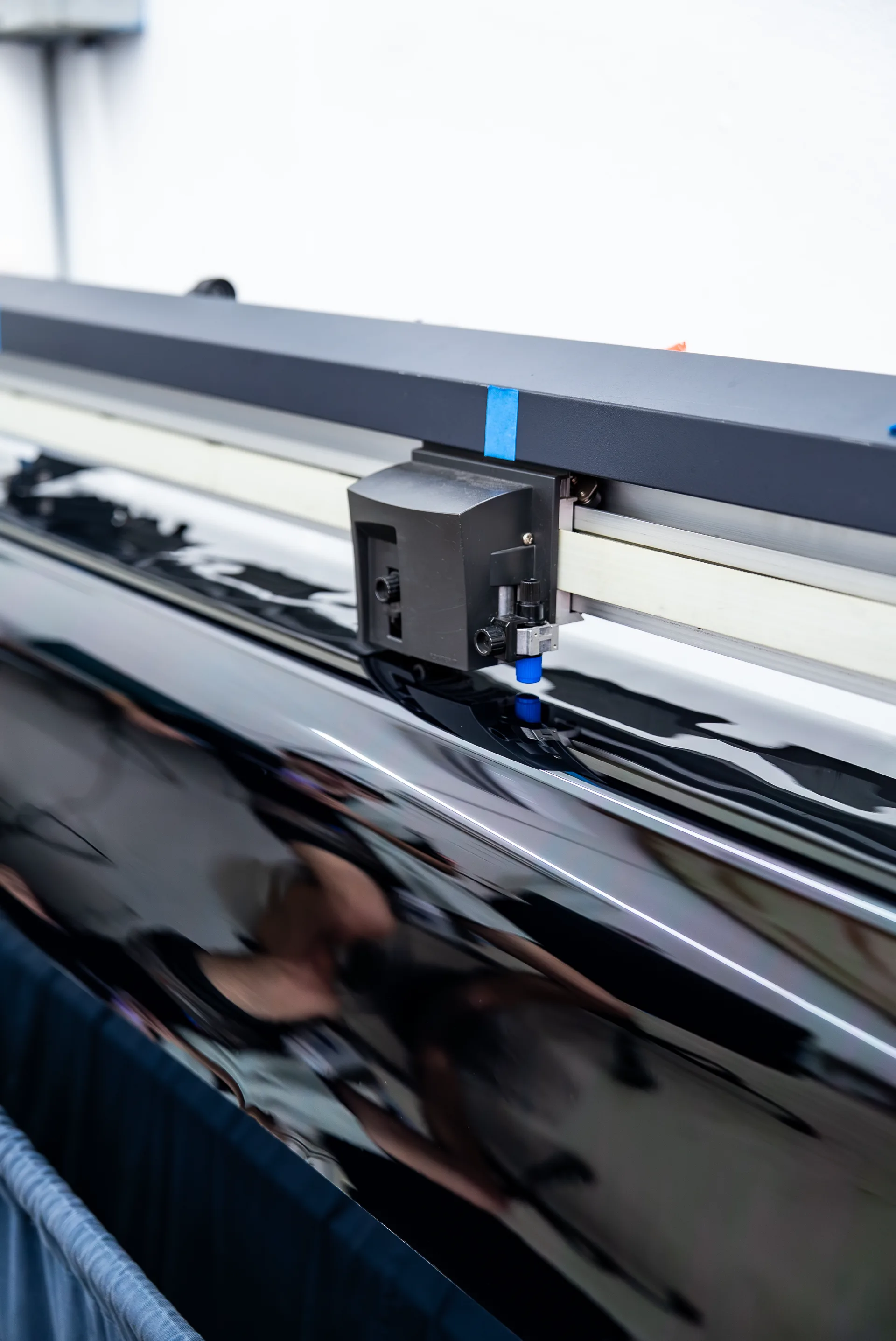 Window tint film being precision-cut on the plotter at Surface Protection Studio