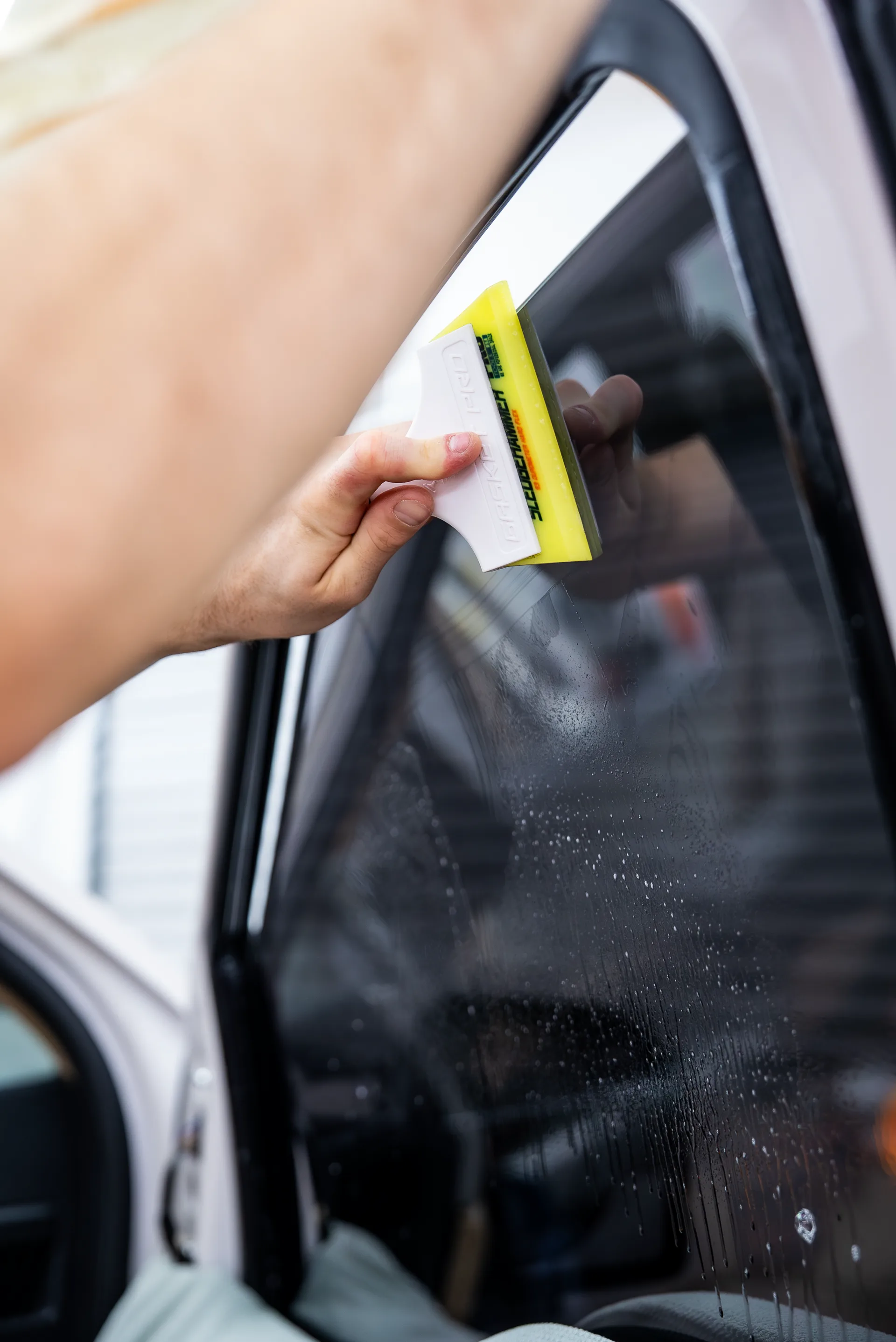 Squeegee passing over a freshly tinted window
