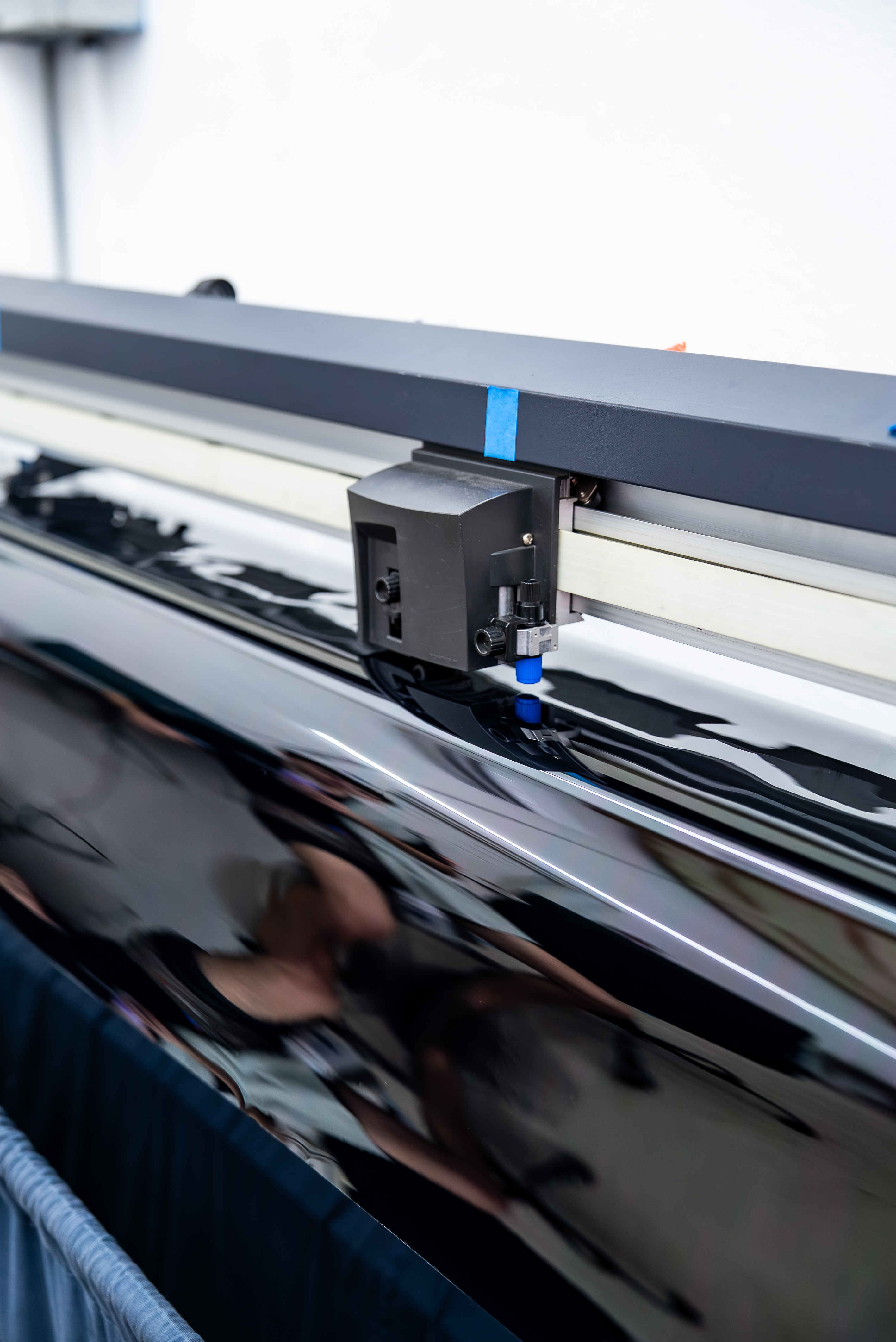 Window tint film being precision-cut on the plotter at Surface Protection Studio